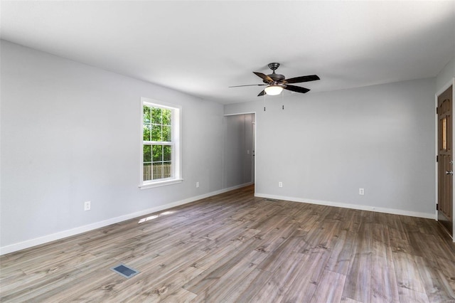 unfurnished room featuring baseboards, ceiling fan, visible vents, and light wood-style floors