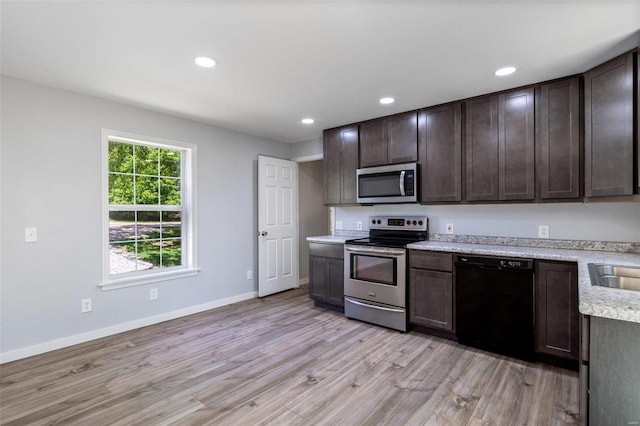 kitchen with light wood finished floors, appliances with stainless steel finishes, light countertops, and dark brown cabinets