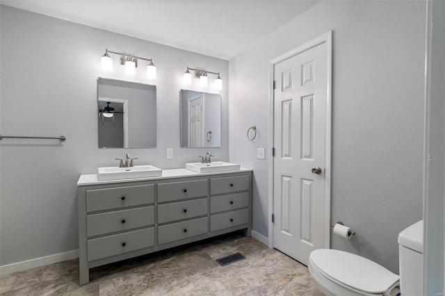 full bath featuring a sink, toilet, and baseboards