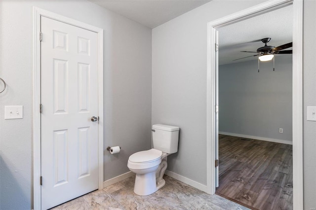 bathroom featuring toilet, baseboards, and a ceiling fan