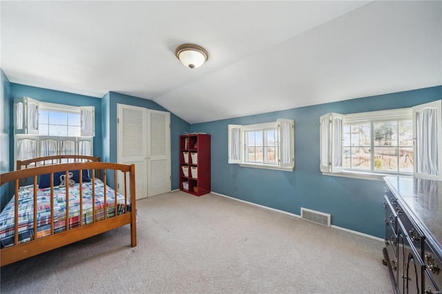 bedroom featuring vaulted ceiling, carpet flooring, visible vents, and a closet