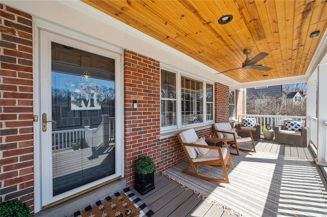 wooden terrace featuring a porch and a ceiling fan