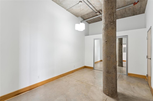 spare room featuring concrete floors and baseboards