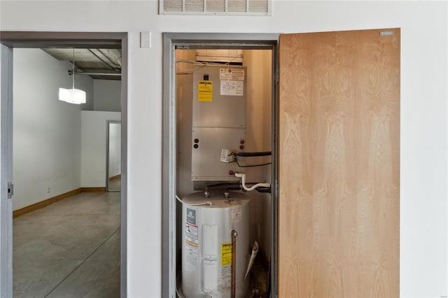 utility room featuring electric water heater and visible vents