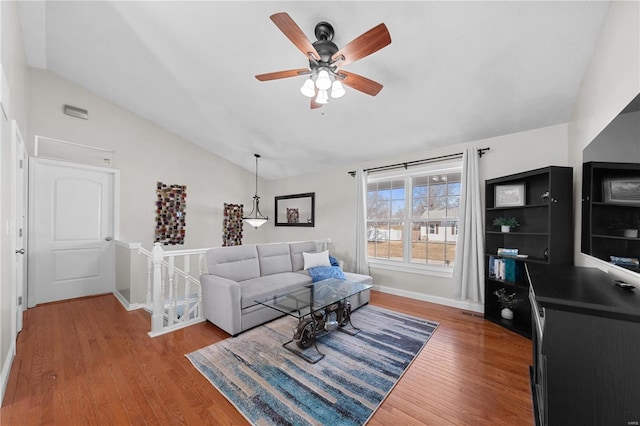 living room with lofted ceiling, a ceiling fan, baseboards, and wood finished floors