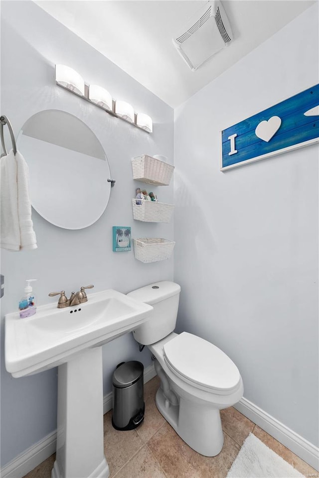 half bathroom with toilet, baseboards, visible vents, and tile patterned flooring