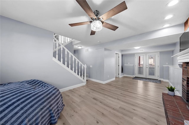 interior space with a fireplace, stairway, baseboards, and wood finished floors