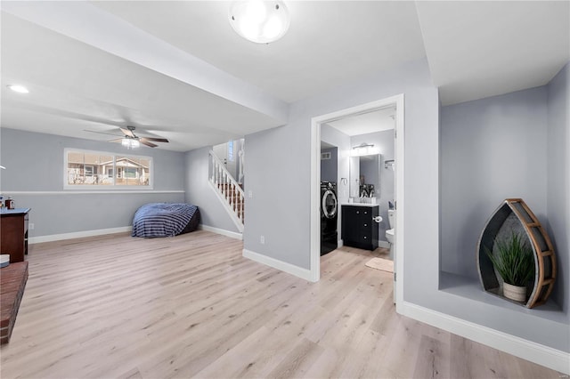 interior space featuring light wood finished floors, washer / clothes dryer, stairway, ceiling fan, and baseboards