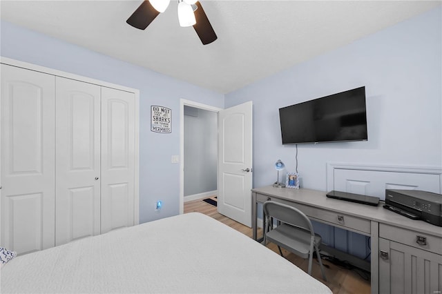 bedroom featuring light wood-style floors, a closet, ceiling fan, and baseboards