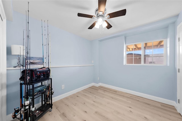 spare room featuring light wood finished floors, baseboards, and a ceiling fan