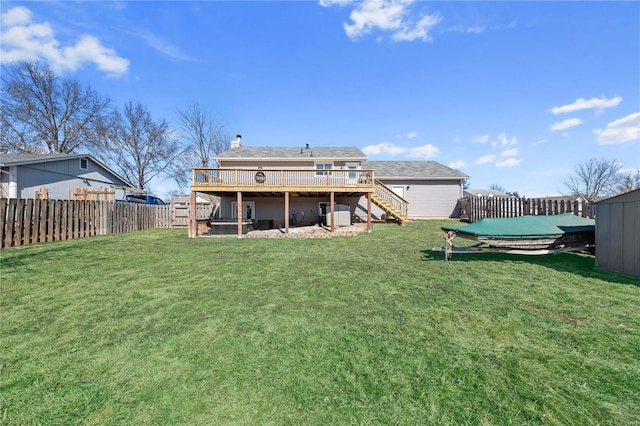 rear view of property featuring a yard, stairway, a wooden deck, and a fenced backyard