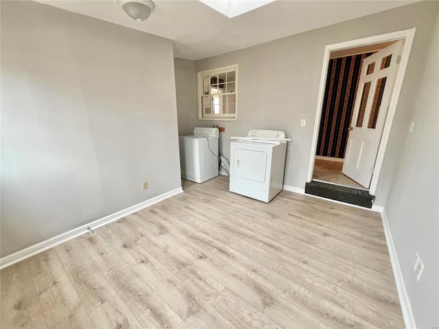 laundry room featuring laundry area, wood finished floors, washing machine and dryer, and baseboards