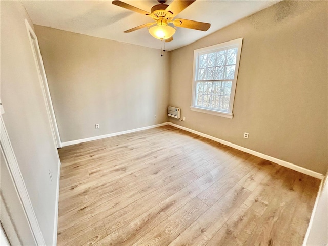 unfurnished room with baseboards, heating unit, wood finished floors, and a ceiling fan