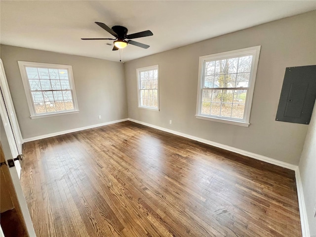 unfurnished room featuring electric panel, dark wood-style floors, ceiling fan, and baseboards