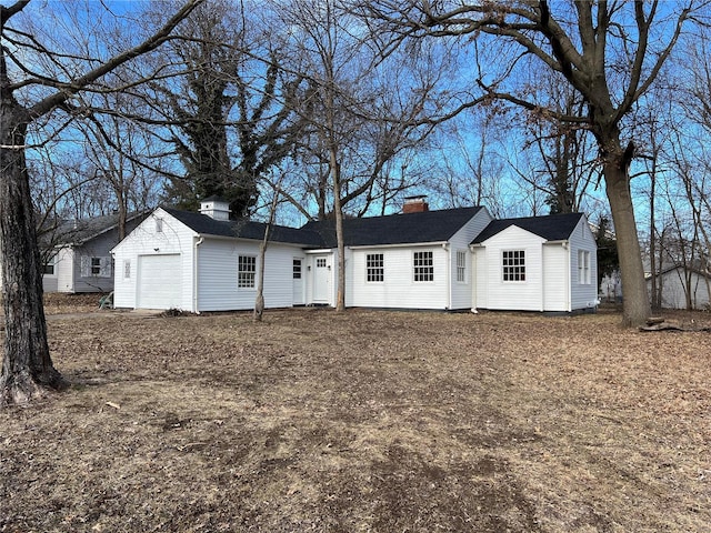 single story home featuring an attached garage and a chimney