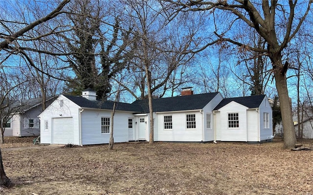 view of front of property featuring an attached garage and a chimney