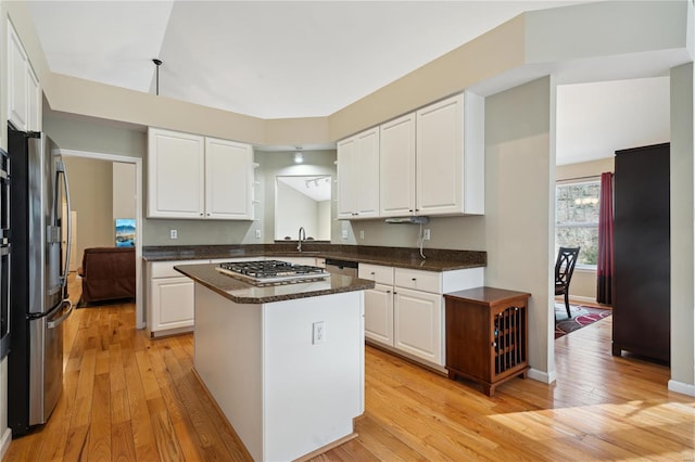 kitchen with stainless steel appliances, light wood-style flooring, a kitchen island, and white cabinetry