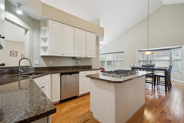 kitchen with white cabinets, dark stone counters, appliances with stainless steel finishes, open shelves, and a sink