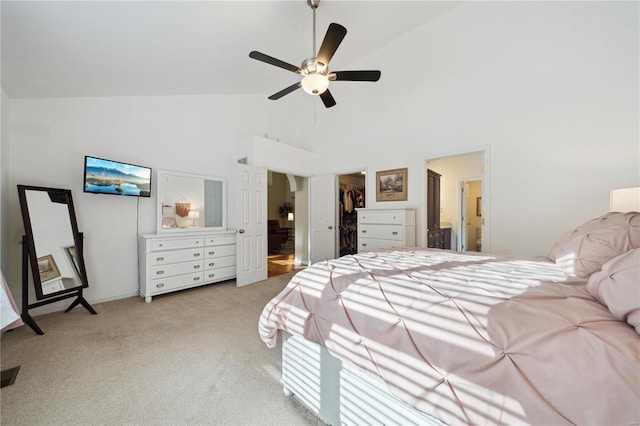 bedroom with light carpet, ceiling fan, ensuite bathroom, a spacious closet, and high vaulted ceiling