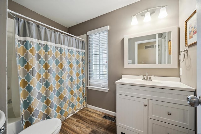 full bathroom featuring toilet, baseboards, visible vents, and wood finished floors