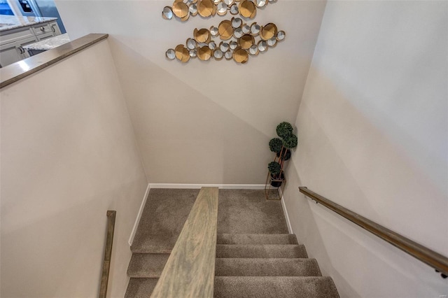 staircase featuring carpet and baseboards