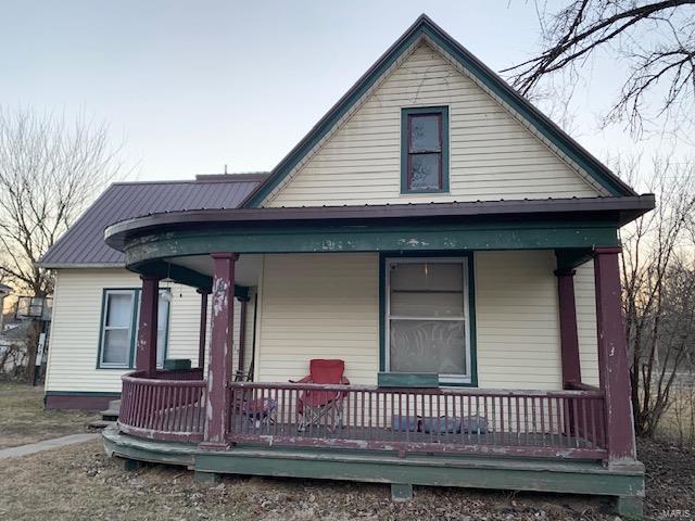 back of house featuring metal roof and a porch