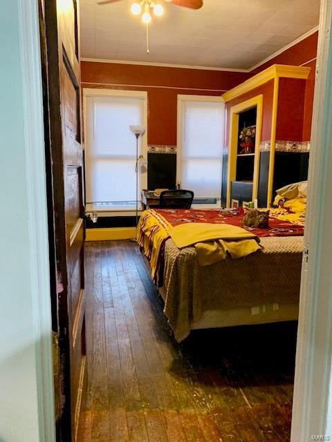 bedroom with ornamental molding, dark wood finished floors, and a ceiling fan