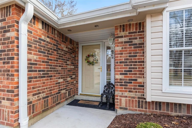 doorway to property featuring brick siding