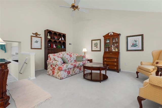 living area with carpet flooring, a ceiling fan, and a towering ceiling