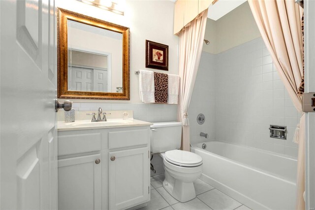 bathroom with toilet, tile walls, shower / tub combo, tile patterned flooring, and vanity