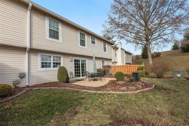 back of property with a patio, a lawn, and fence