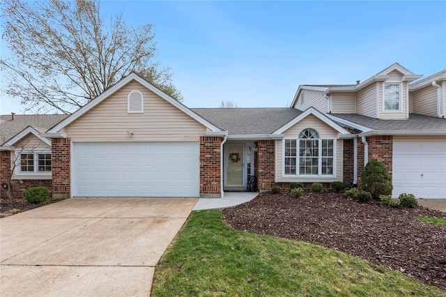 view of front facade with brick siding, an attached garage, concrete driveway, and a shingled roof