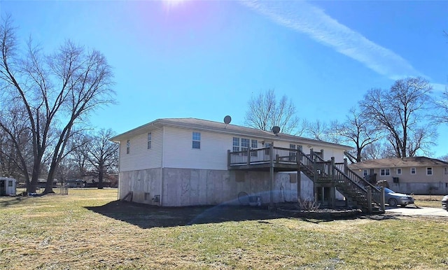 rear view of house with a lawn, stairway, and a wooden deck