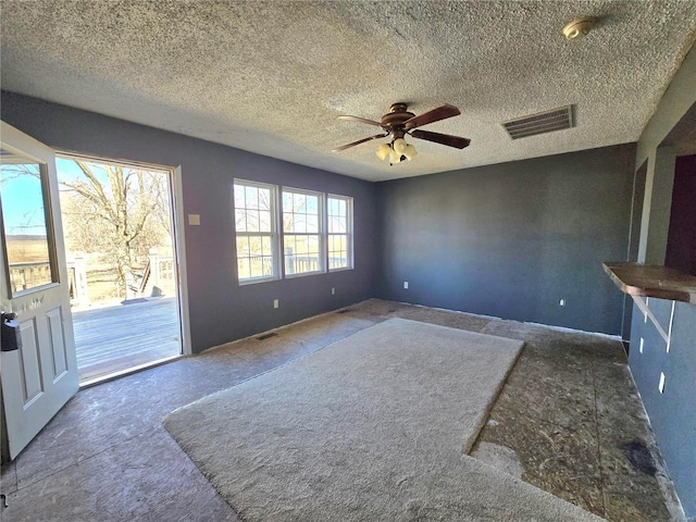 interior space with ceiling fan, a textured ceiling, and visible vents