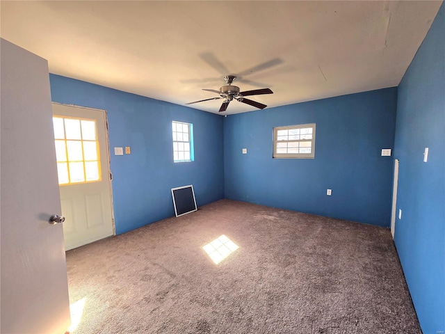 empty room with carpet floors, plenty of natural light, and a ceiling fan