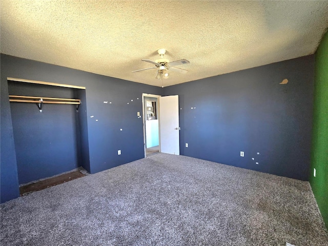 unfurnished bedroom featuring a textured ceiling, carpet floors, a closet, and a ceiling fan