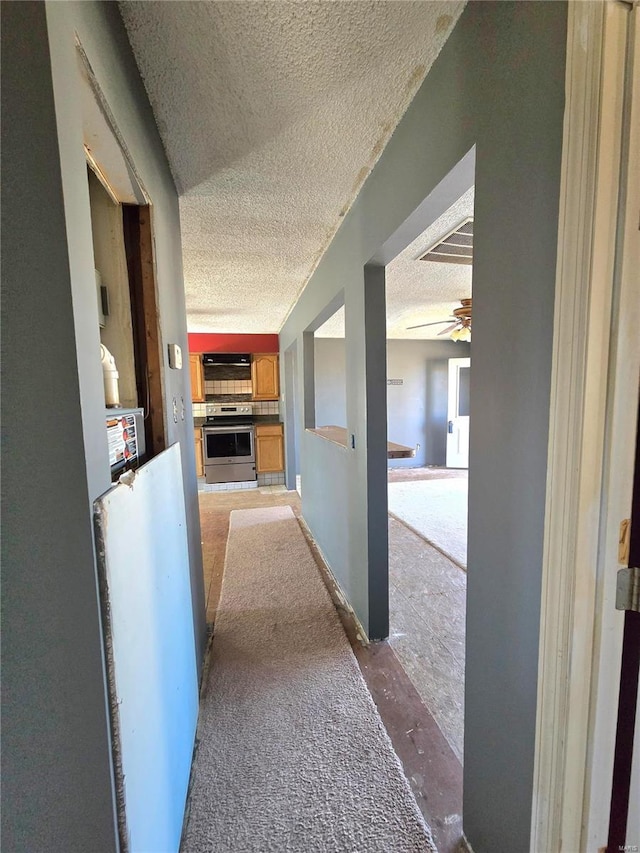 hallway featuring visible vents and a textured ceiling