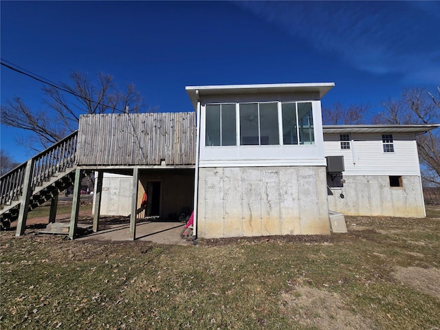 rear view of property with stairs and a sunroom