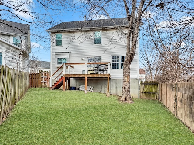 rear view of property featuring a deck, a lawn, and a fenced backyard