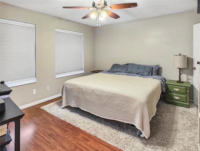 bedroom with wood finished floors, a ceiling fan, and baseboards