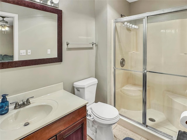 bathroom featuring vanity, a shower stall, and toilet