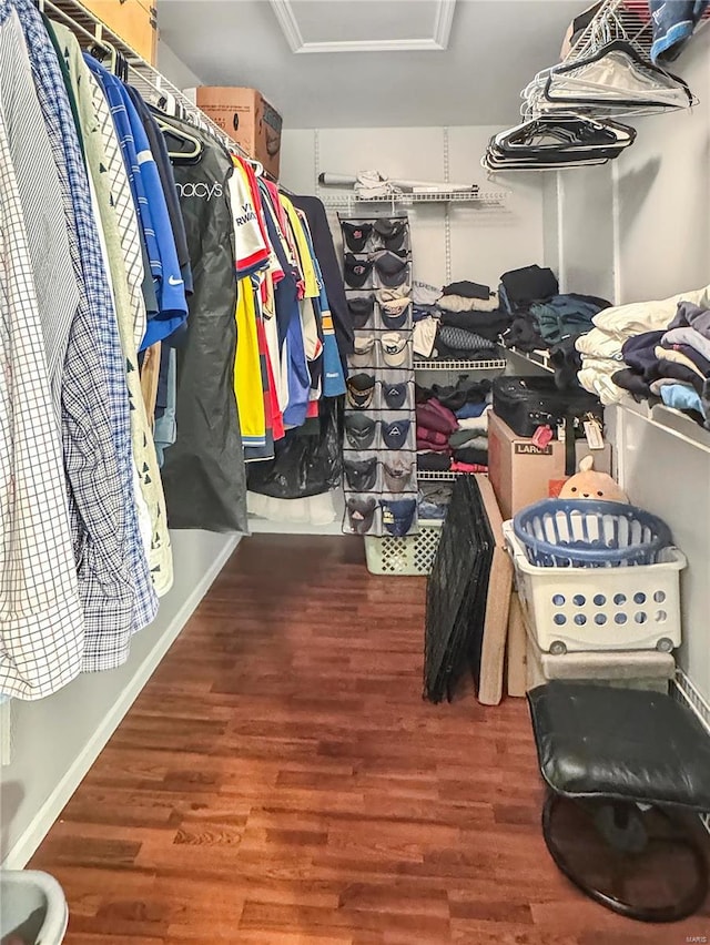 spacious closet with attic access and wood finished floors