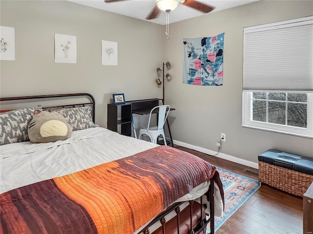 bedroom featuring wood finished floors, a ceiling fan, and baseboards