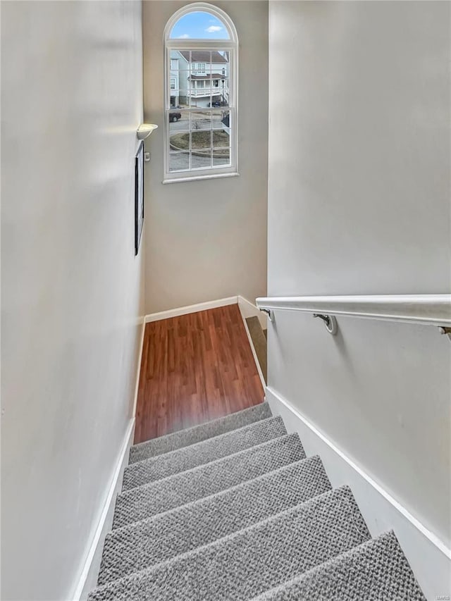 stairs with wood finished floors and baseboards