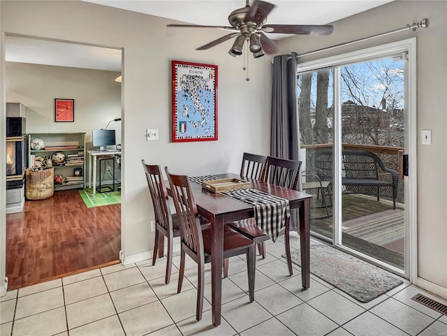 tiled dining area with a ceiling fan and visible vents