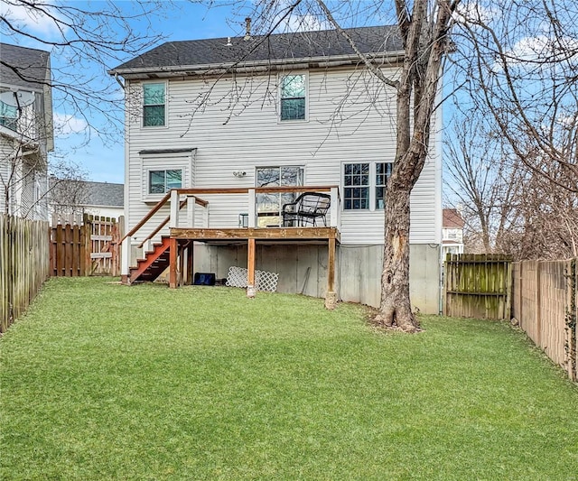 back of house featuring a fenced backyard, a lawn, a wooden deck, and stairs