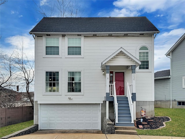 traditional-style home with a garage, a shingled roof, fence, and concrete driveway