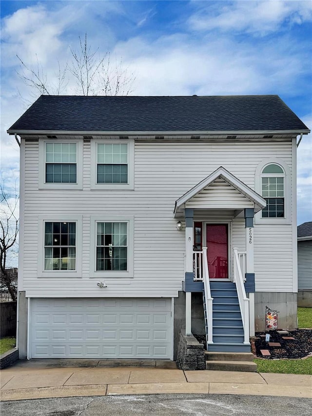 traditional home featuring a shingled roof and an attached garage