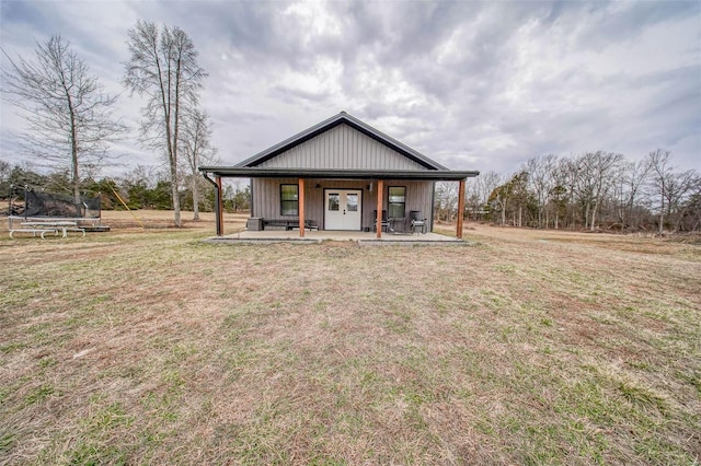 view of front of house with covered porch, a trampoline, and a front lawn