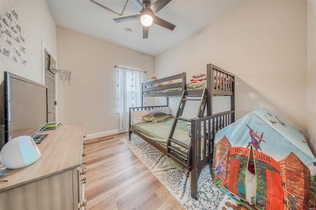 bedroom featuring visible vents, ceiling fan, baseboards, and wood finished floors